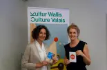 Nathalie Benelli, Kultur Wallis, und Céline  Fallet, wemakeit.ch, freuen sich über die  erfolgreichen Walliser Projekte auf der  Schwarmfinanzierungs-Plattform.
